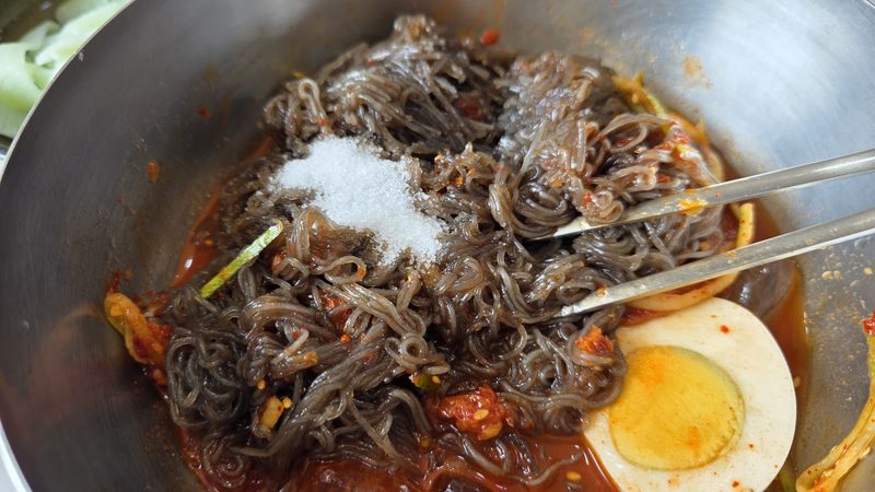 양념장과 설탕을 넣고 비비는 냉면